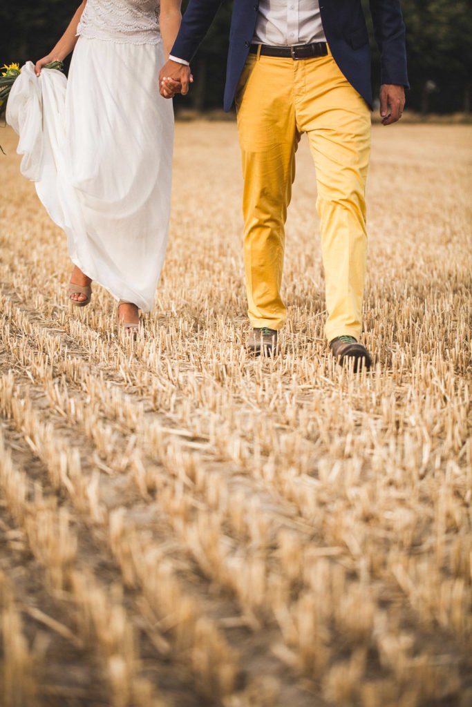 Deux mariés qui se tiennent par la main lors d'une séance photo de couple