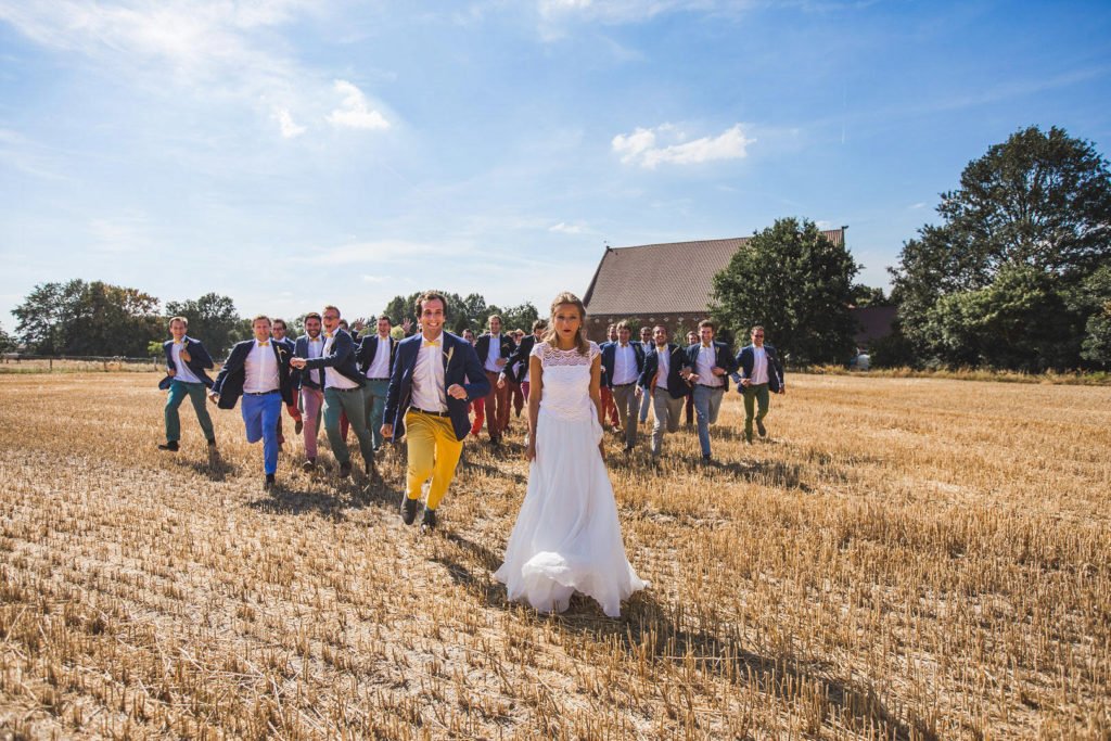 Témoins de mariage qui courent dans un champ autour de la mariée