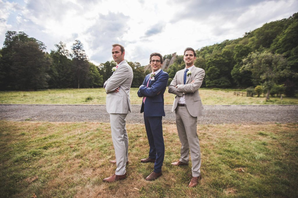 Témoins de mariage qui posent avec le marié les bras croisés