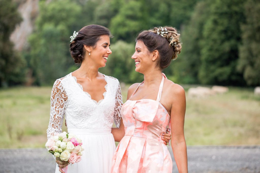Mariée qui pose avec sa témoin de mariage, avec un flou d'arrière plan
