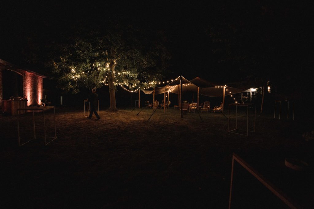 Des tentes de cérémonie de mariage avec des guirlandes d'ampoules dans les arbres
