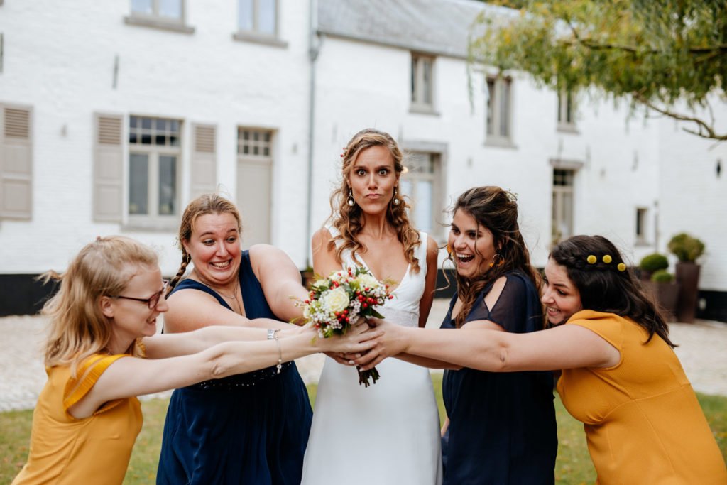 Photo des témoins de mariage de la mariée qui posent avec le bouquet de fleur, dans un style de photo moody