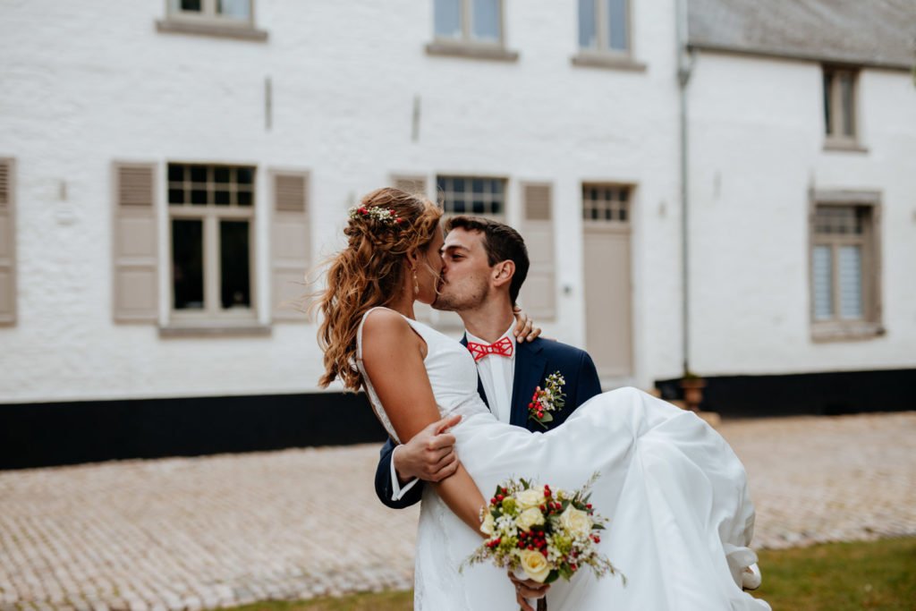 Couple de mariés qui s'embrassent lors d'une séance photo de couple par le photographe Maxime du Bus
