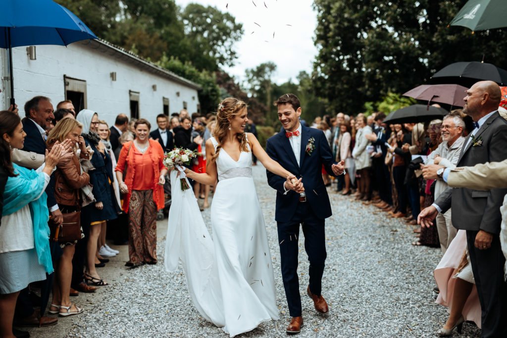 Une haie d'honneur avec les mariés au milieu et du riz