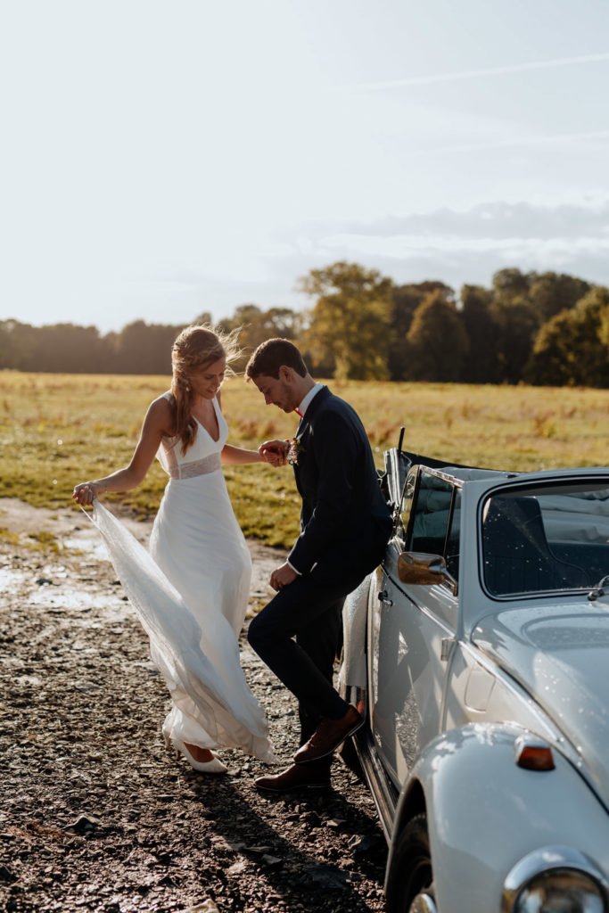 Deux mariés qui posent à leur mariage lors d'un coucher de soleil