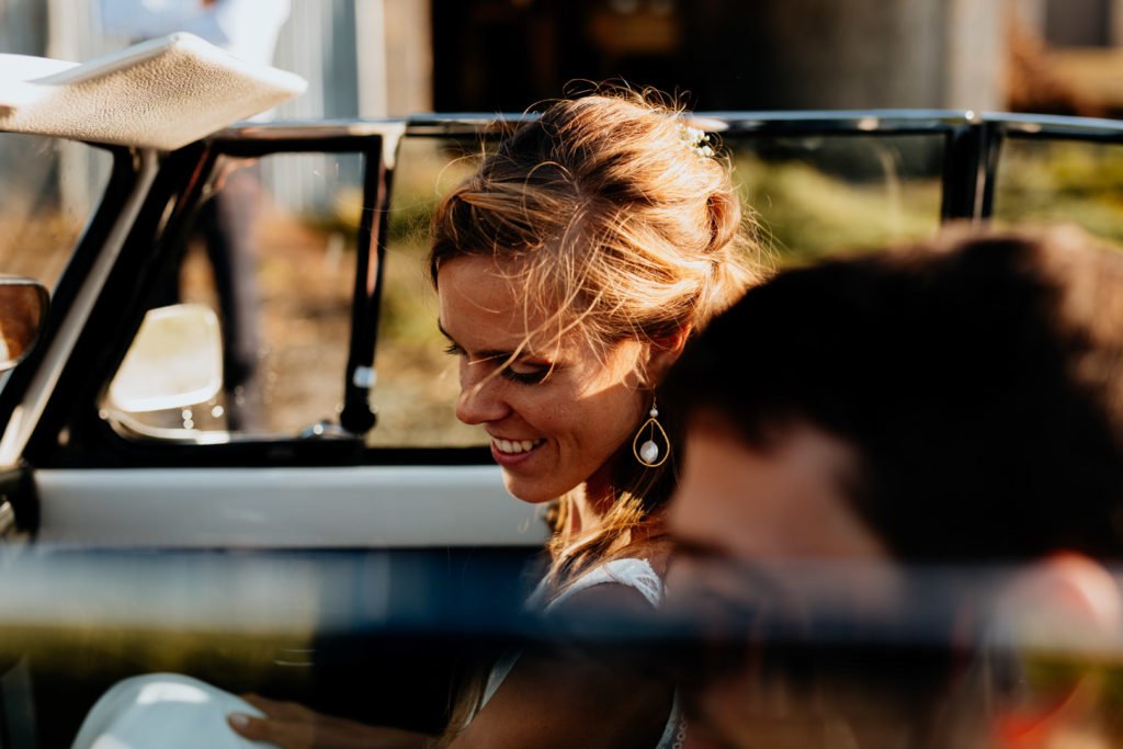 une mariée dans une deux chevaux lors d'une séance photo de couple