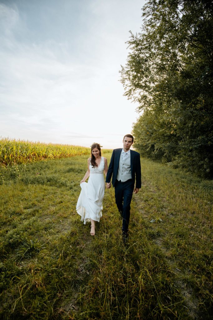 Les mariés se tiennent par la main lors d'une séance photo de mariage
